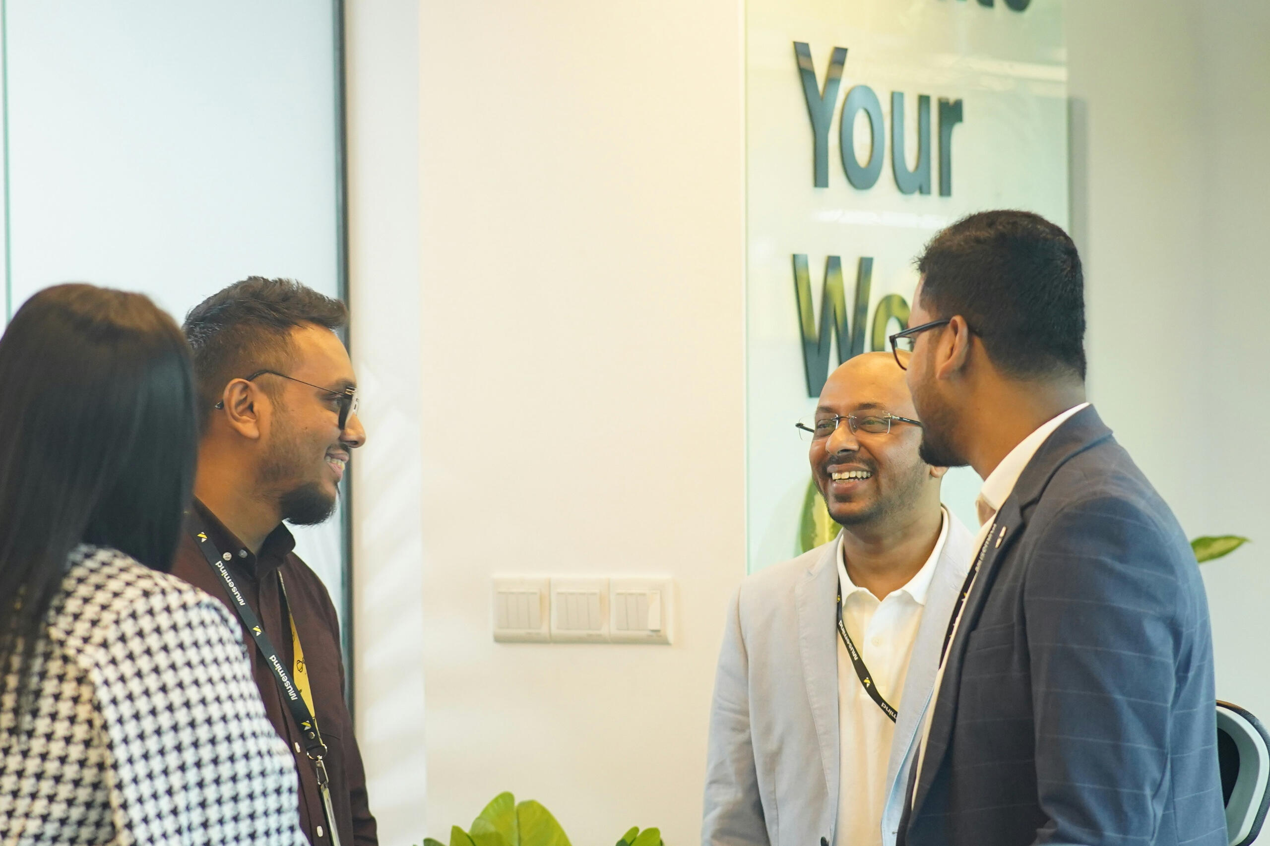 4 people at a wall conversing with each other